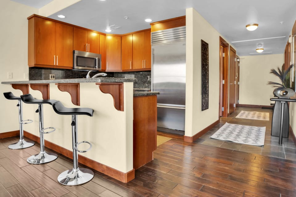 The breakfast bar offers seating for four on shining metal and black leather bar stools.