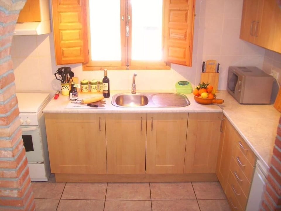 kitchen with oven, microwave, dishwasher and fridge freezer with view to garden 