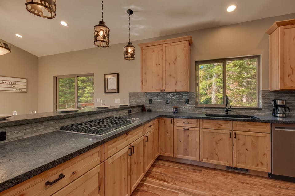 - Fully equipped kitchen with gas cooktop  
- Large windows bring forest views inside  
- Ideal space for preparing family meals