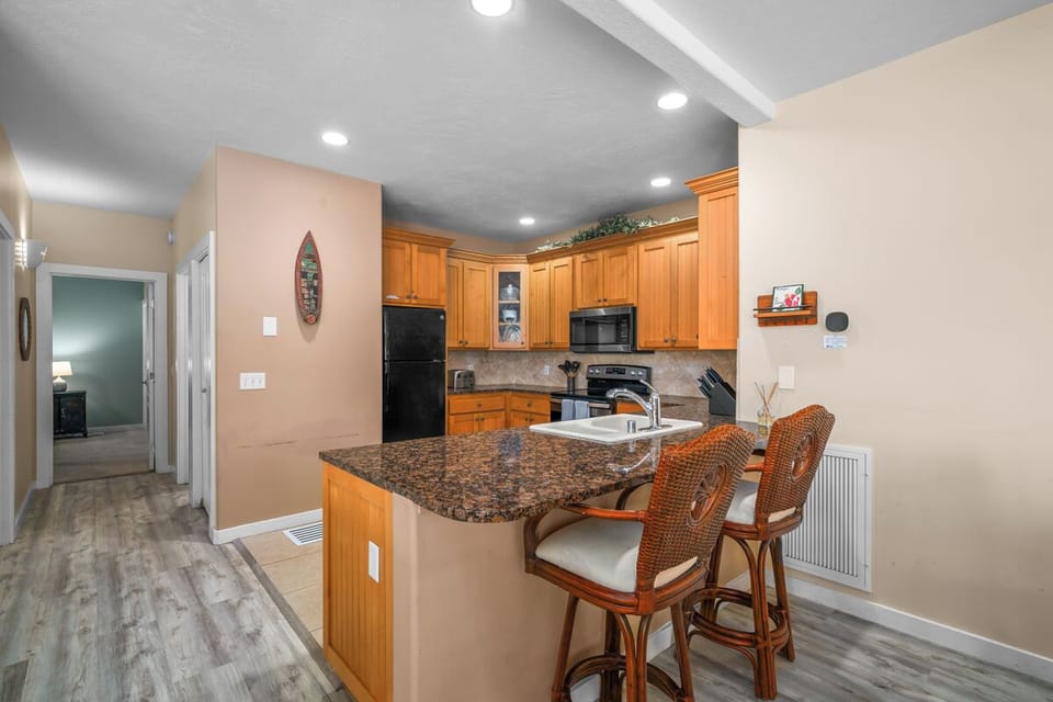 Your fully equipped kitchen features granite counters, modern appliances, and a breakfast bar where you can sip morning coffee or plan the day's adventures.