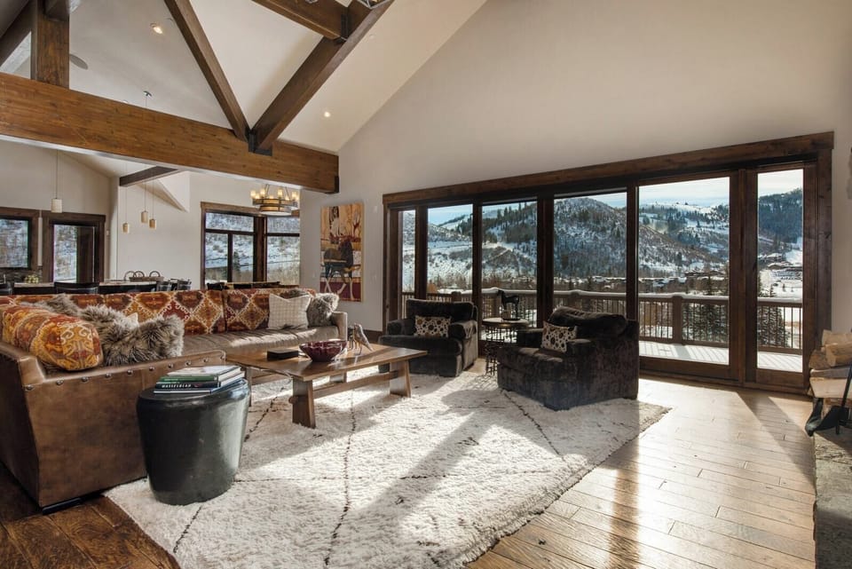 A wall of windows brings the outdoors in to this light-filled main living space with vaulted ceilings and plush seating.
