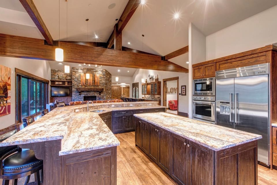 Cook with ease in the open chef’s kitchen with a wraparound island, stainless appliances, and seating for five.