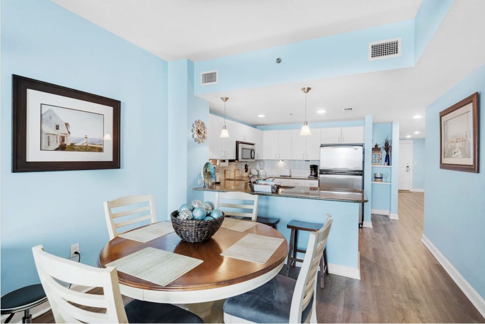 Your coastal-themed dining space flows seamlessly into a fully equipped kitchen with stainless steel appliances and granite countertops.