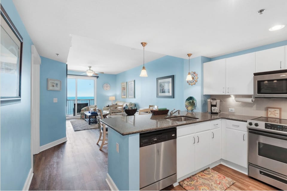 Your modern kitchen flows seamlessly into the bright living space, with ocean views framing your cooking and dining experience.