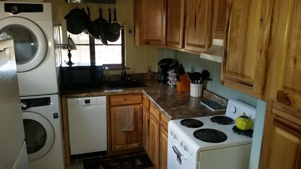 Kitchen with electric stove, dishwasher, washer/dryer, microwave, keurig, and coffee pot