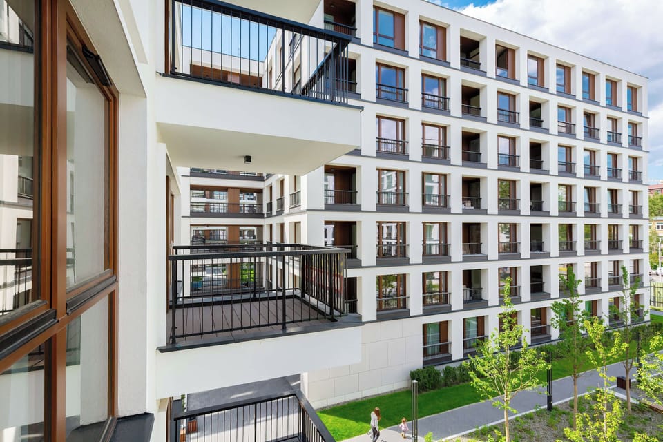 A view of the modern residential building with green courtyards and balconies.