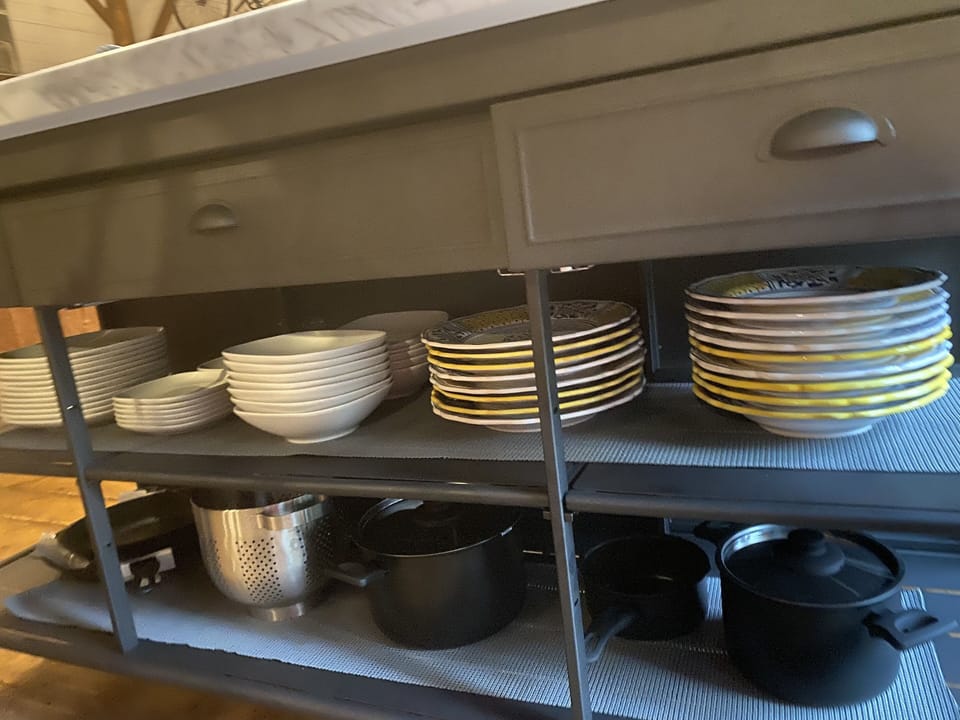 Center Island contains plenty of dishes , pots pans cutlery