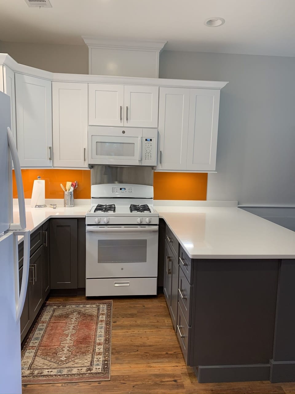 Kitchen with quartz countertops. Ice maker in fridge. Gas range.
