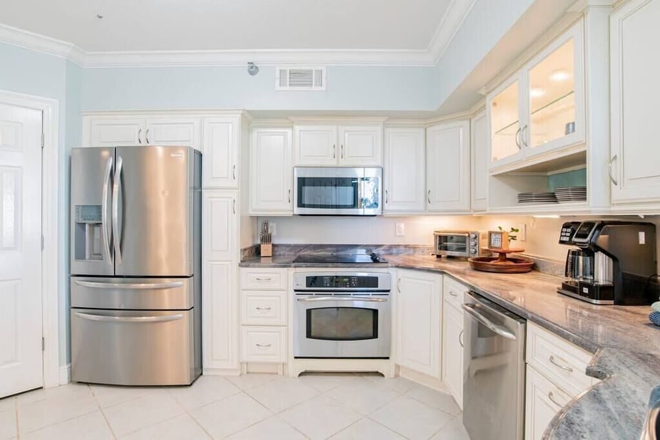 Well stocked kitchen features granite counter tops and stainless steel appliances.