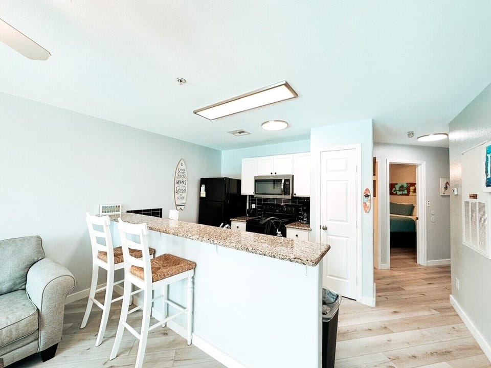 The kitchen opens into the living area and also has a great view of the lovely resort pool.