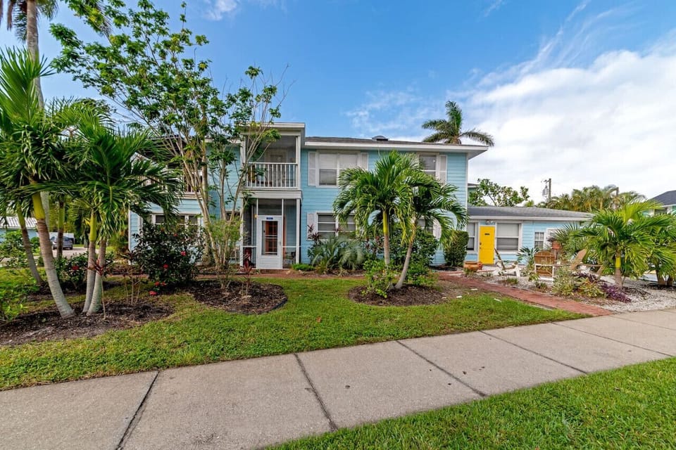 Siesta Key beach complex with lush landscaping, palms & blue charm—styled for breezy stays and relaxed coastal ease.