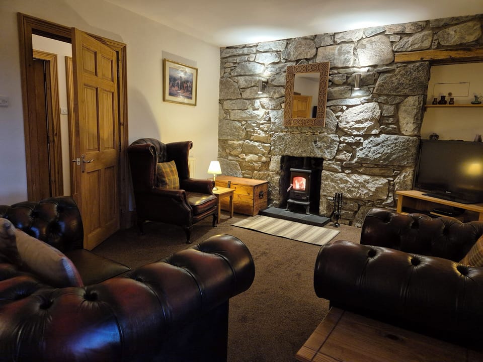 Very spacious living room, chesterfield suite, granite stone wall & woodburner.