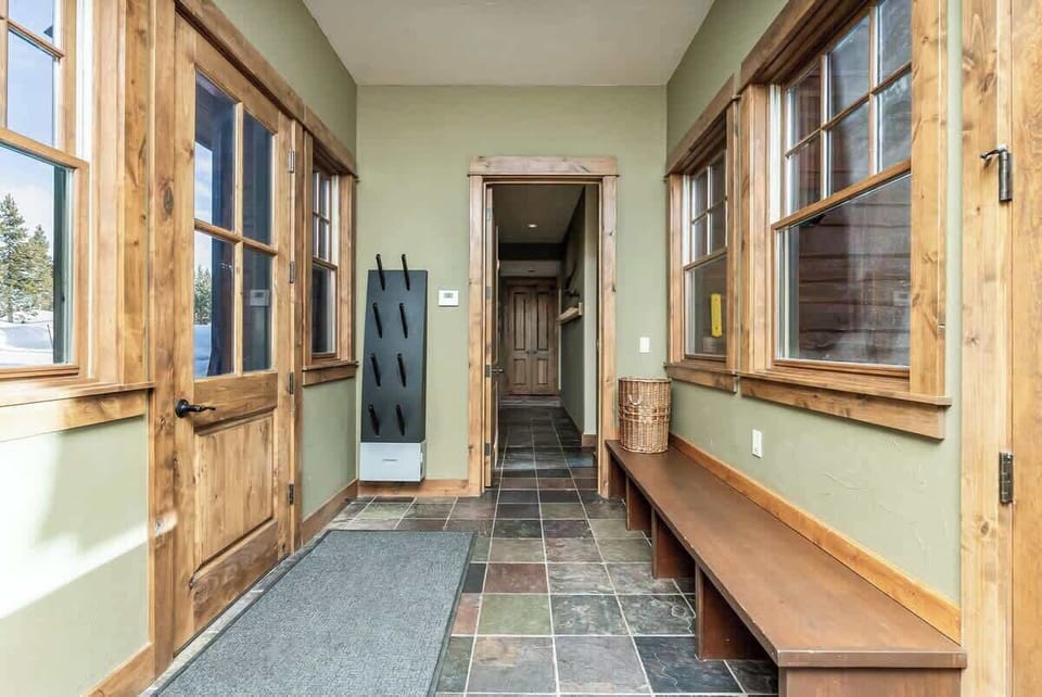 Side entry way with hooks for ski gear, benches, and boot dryers