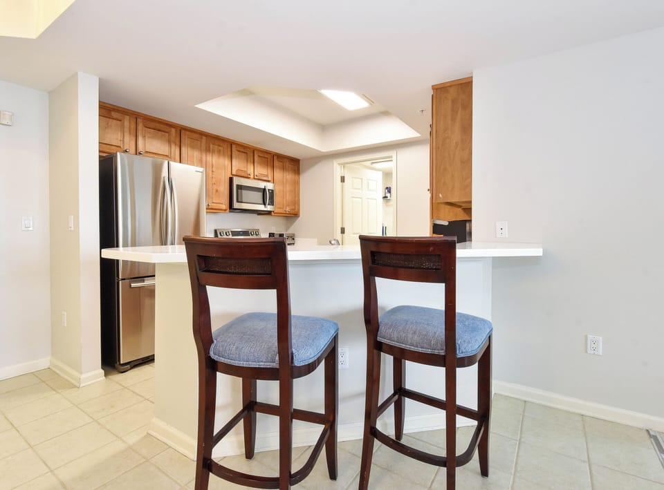 You'll love cooking in this bright, fully-equipped kitchen with stainless steel appliances, warm wood cabinetry, and a breakfast bar for casual dining.