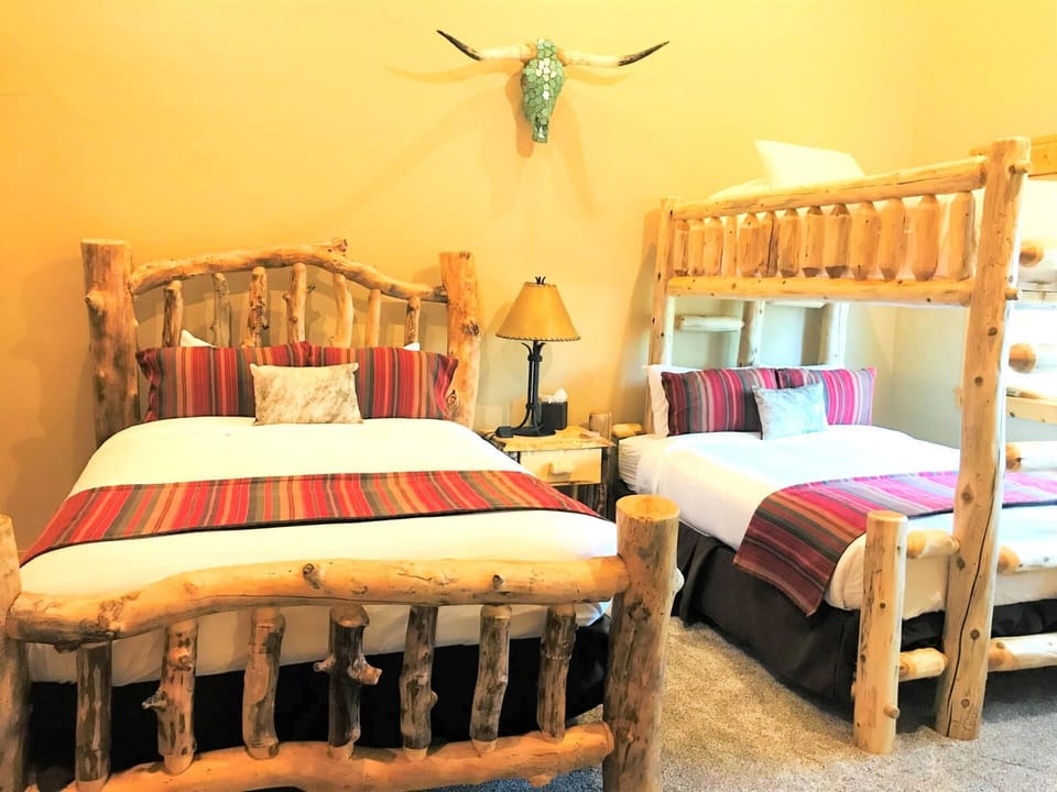 The second bedroom includes two Queen beds and a bunk, creating a flexible space for kids or friends.