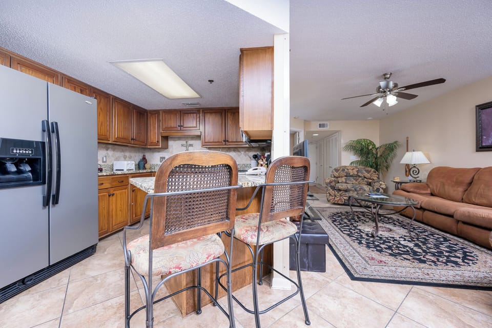 The inviting kitchen features rich wood cabinetry, a breakfast bar with seating, and stainless appliances 