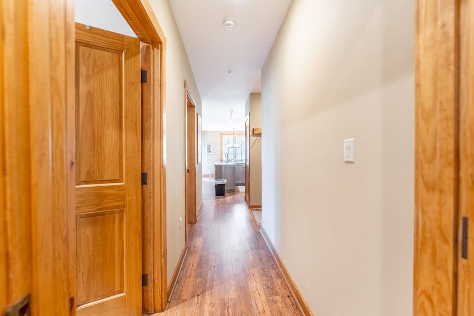 Step through the warm hallway where rich wood floors and beams create a welcoming path to your spacious kitchen.