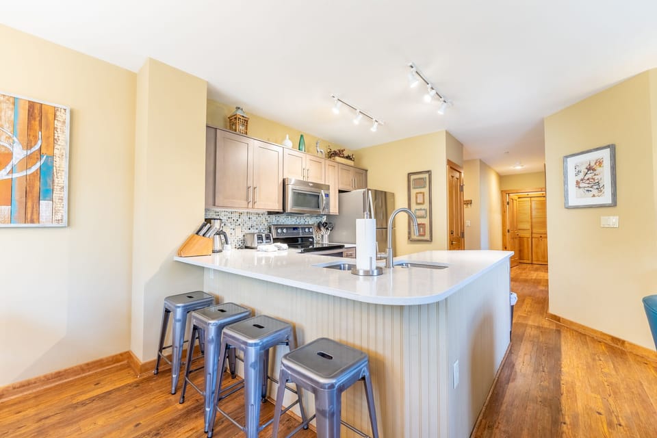 Your modern kitchen features gleaming countertops, stainless steel appliances, and a breakfast bar perfect for morning coffee or casual dining.