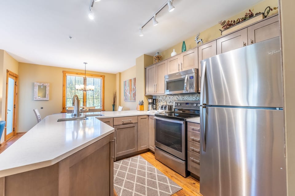 Your spacious kitchen features modern stainless steel appliances, elegant countertops, and warm wood floors—perfect for preparing memorable meals during your stay.
