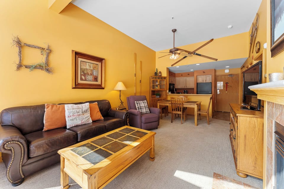 Relax in your cozy living space with leather seating, warm wood accents, and an open kitchen perfect for preparing meals together.