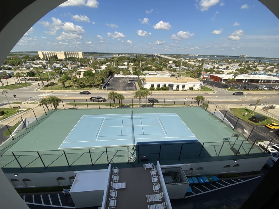 Tennis court with basketball hoop on top of the parking garage.