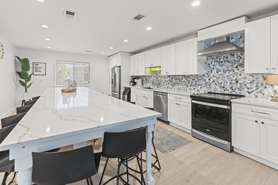 Step into your modern kitchen with gleaming marble countertops, stainless steel appliances, and stylish mosaic backsplash where culinary adventures await.