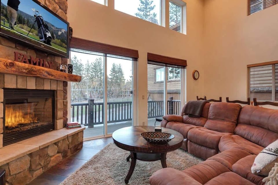Grand Living room with views of the golf course. Smart tv and gas fireplace in front of the large sectional couch.