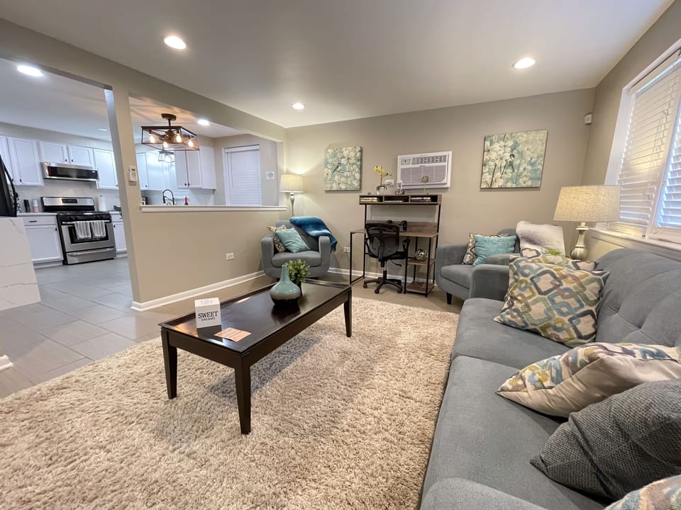 The living room is equipped with Comfy living room seating, & decorative pillows