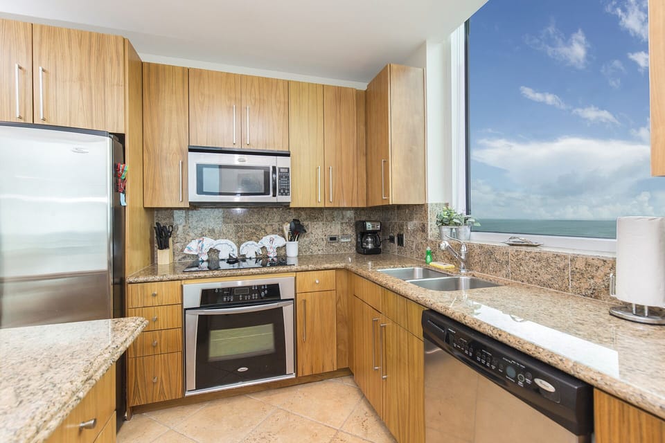 Kitchen has stainless steel appliances and is fully stocked with utensils, cook and dish wares.