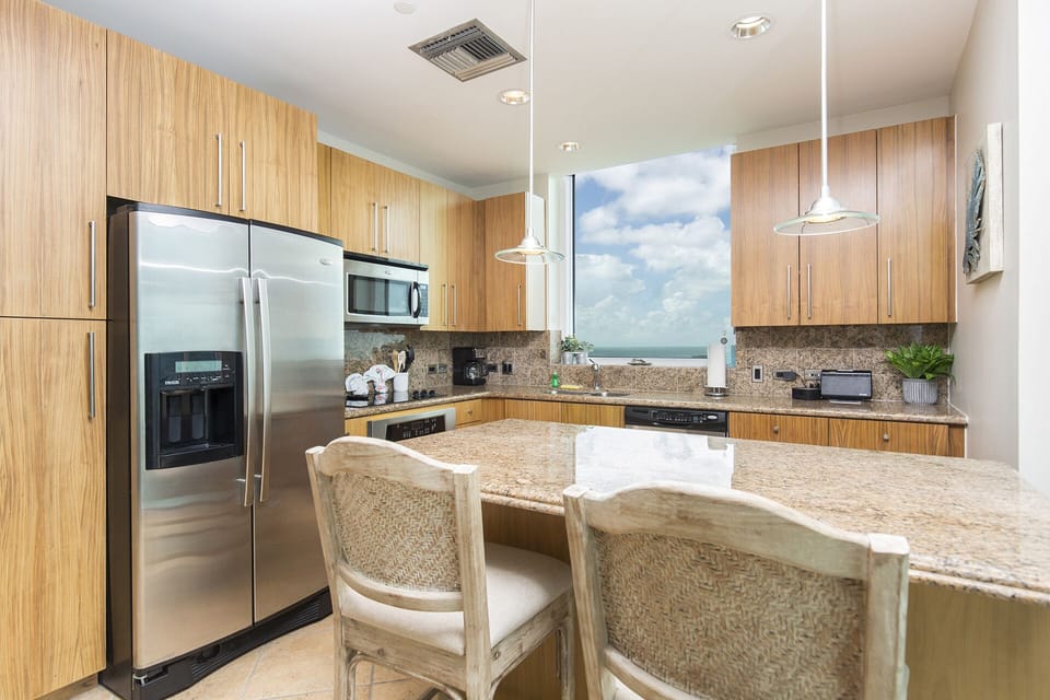 Modern kitchen with stainless steel appliances and bar seating for two additional guests.
