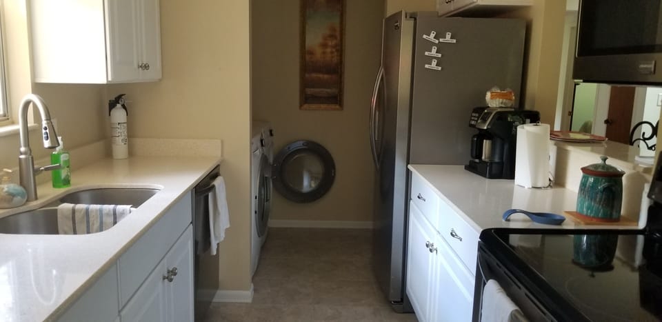 Galley kitchen with stainless steel appliances.  Washer and dryer and pantry.