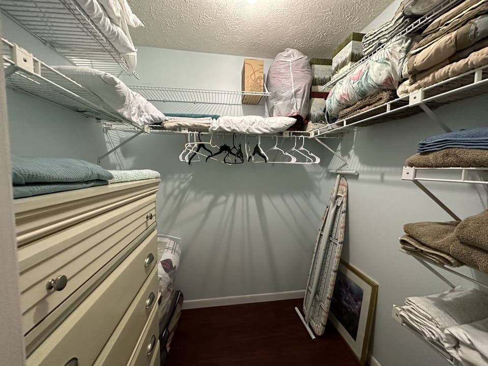 Master bedroom walk in closet, lots of storage & chest of drawers. Iron & board
