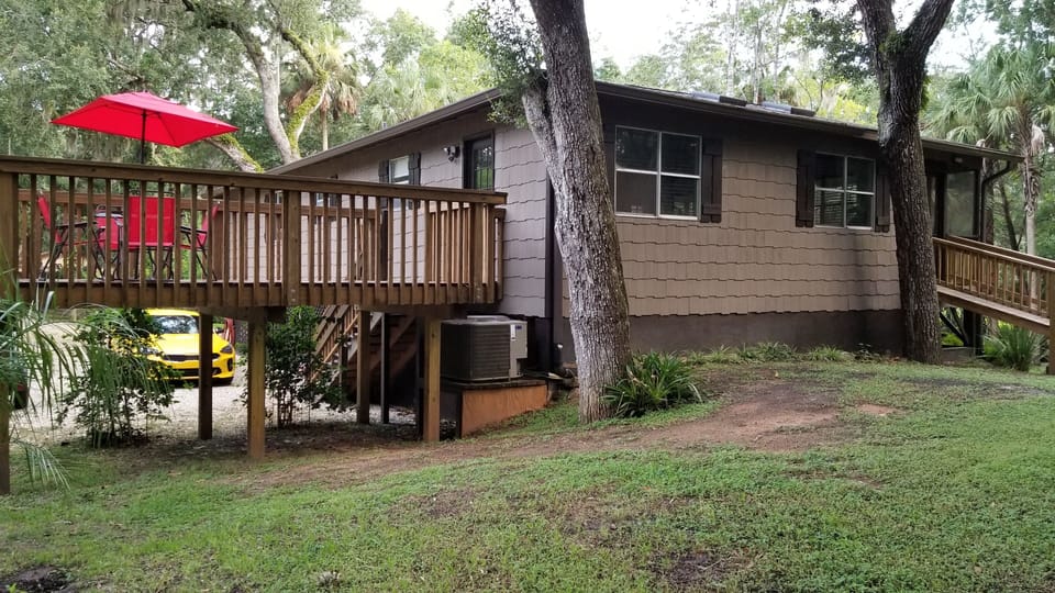 Back of house.  Open deck with table and chairs
