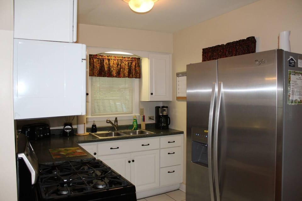 Fully equipped kitchen on the main living level, with stainless steel gas stove, refrigerator with automatic ice maker,  over the range microwave and k-cup/coffee pot combo
