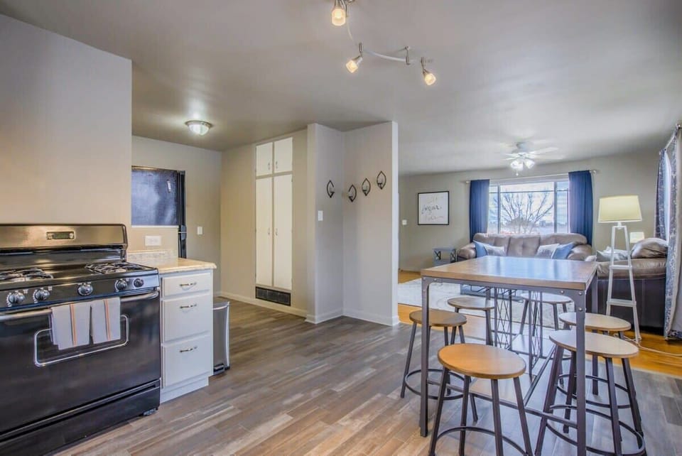 Open kitchen-dining setup with range, island seating, and a table ready for meals—plate up dinner, pull up a stool for conversation while you cook, then gather at the table for shared bites and lingering laughs.
