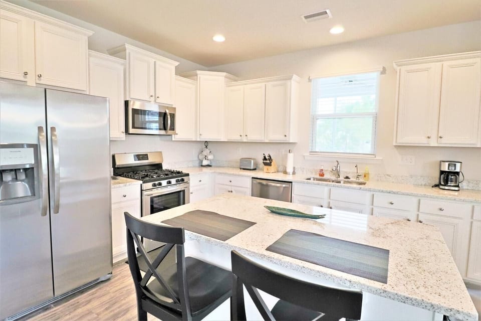 The modern kitchen includes top of the line stainless applainces with a gas stove.