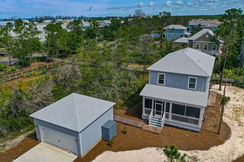 Aerial view of the property featuring the front screen porch and access to the two car garage.