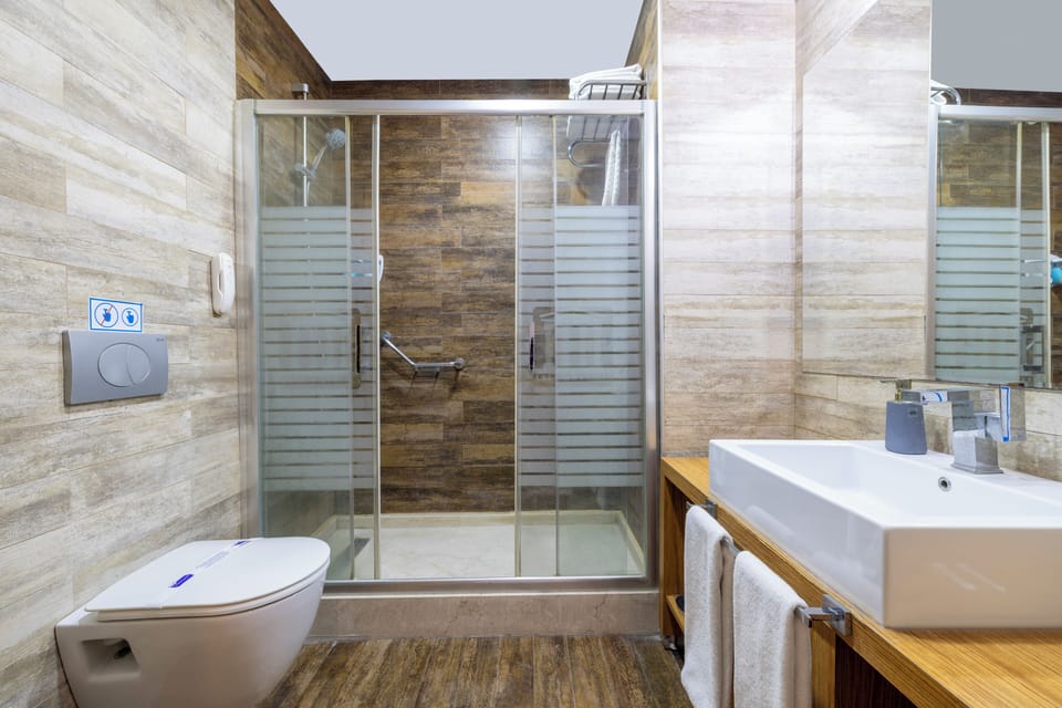Deluxe Room | Bathroom | Hair dryer, slippers, towels, soap