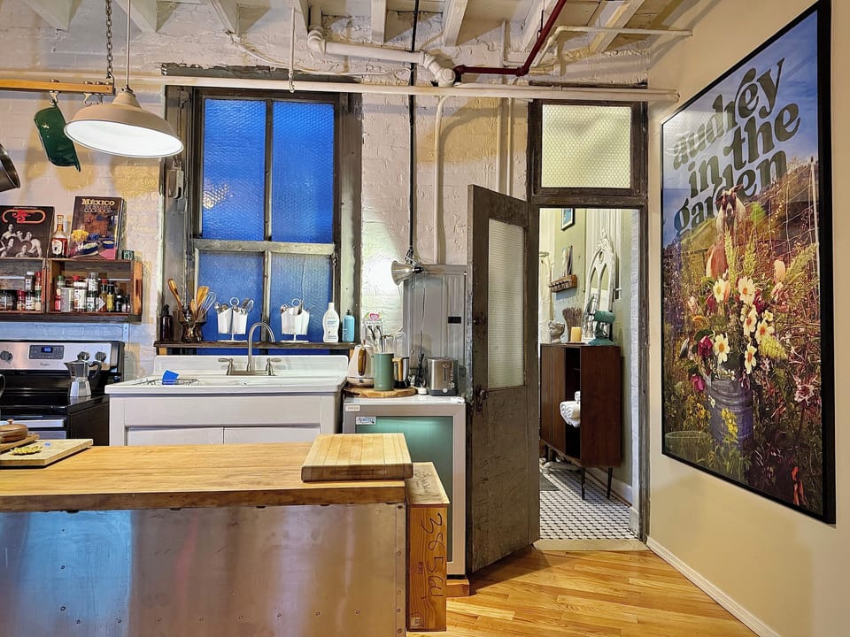 Open loft kitchen with exposed brick and original vintage window