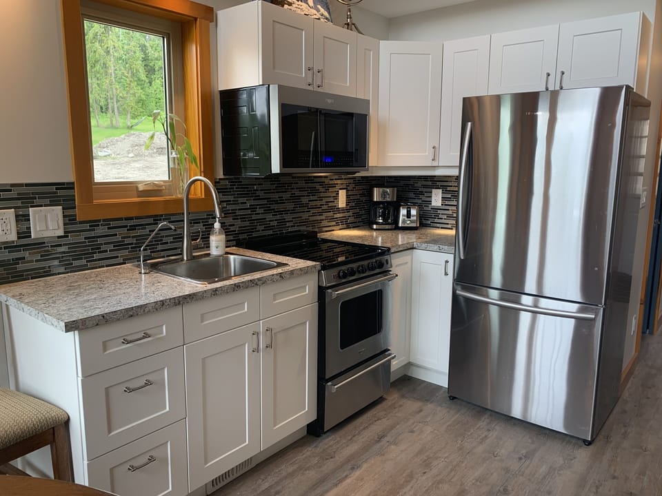 Fully stocked Kitchen area with stove, microwave, full-size fridge
