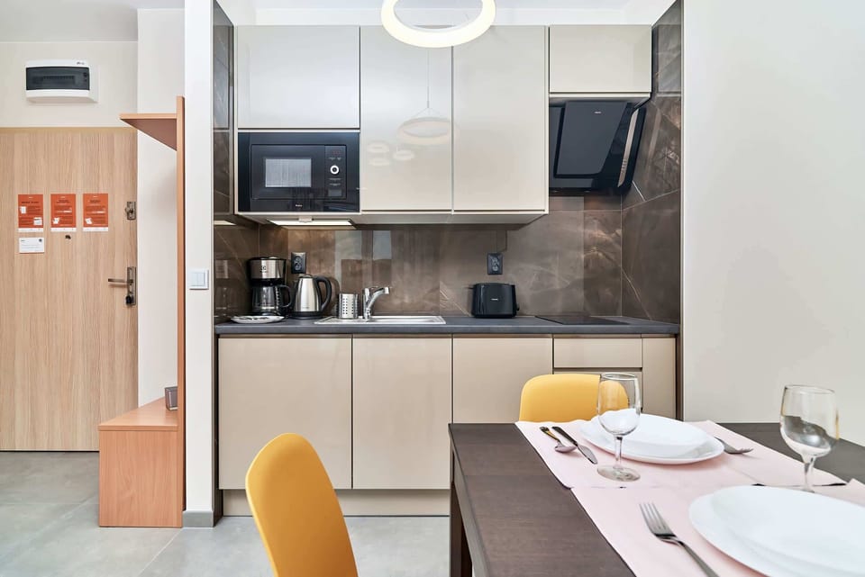Fully equipped kitchenette and dining table with tableware.