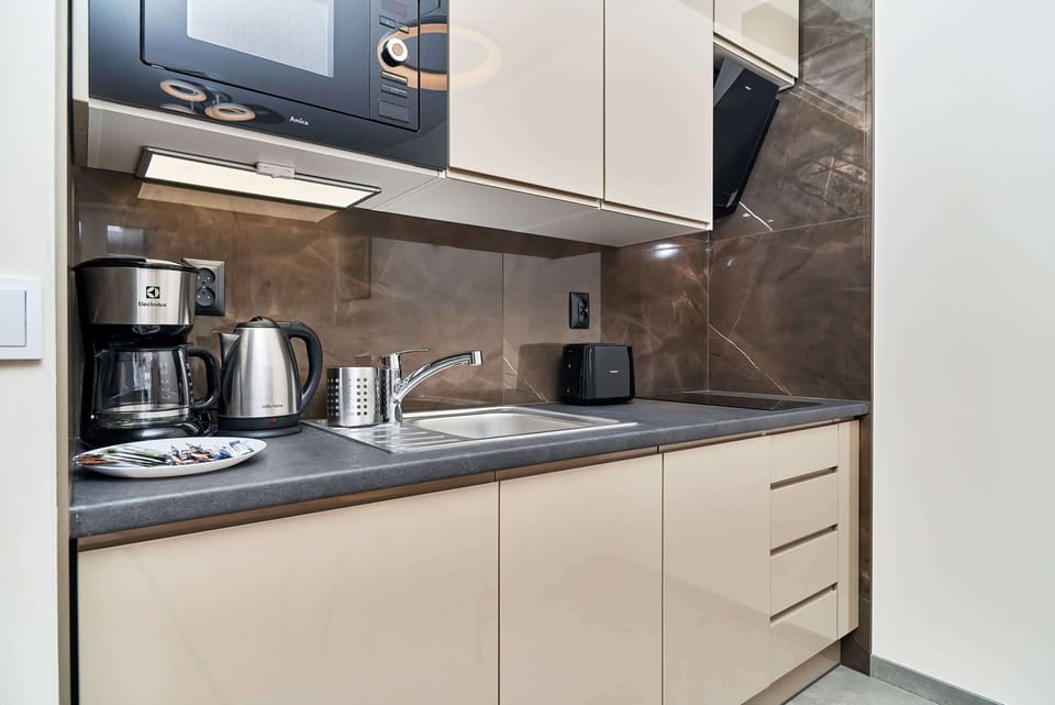 Fully equipped kitchenette with electric hob, microwave, fridge, dishwasher, coffee machine, kettle and toaster.