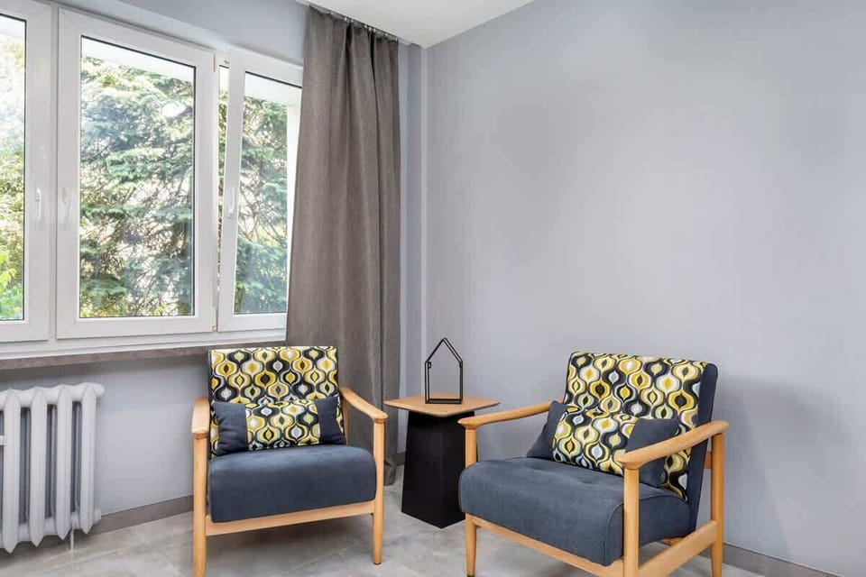  Two yellow and gray patterned armchairs, creating a cozy seating area.
