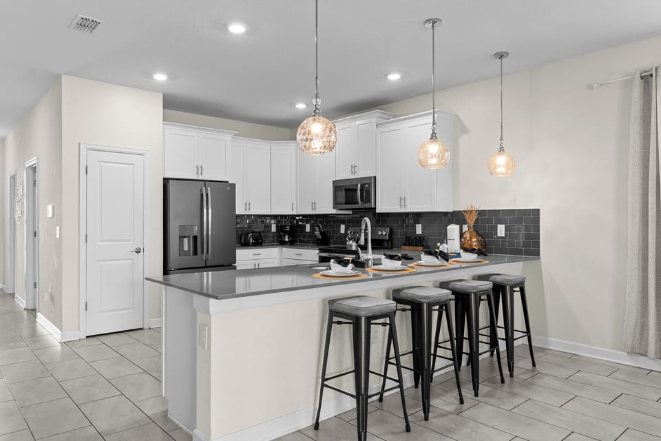 Gather around this spacious kitchen island where you'll create memorable meals with modern appliances and elegant pendant lighting.