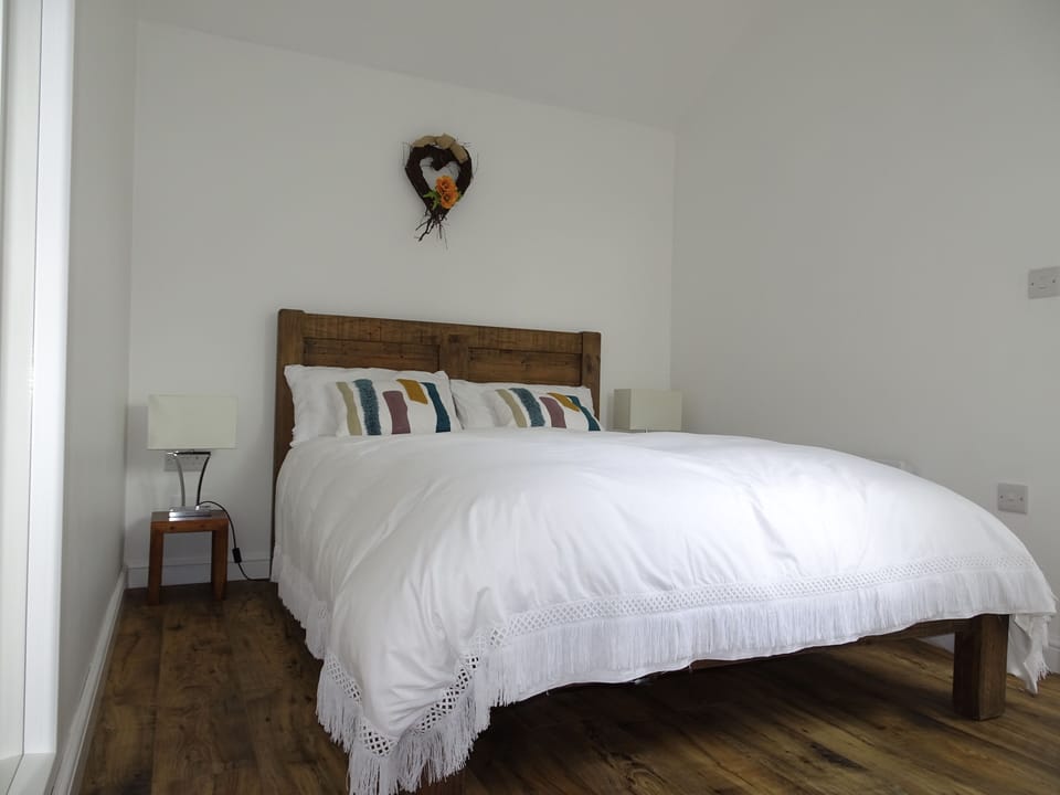 Double bedroom with hanging space and under-shelf storage, view to patio area
