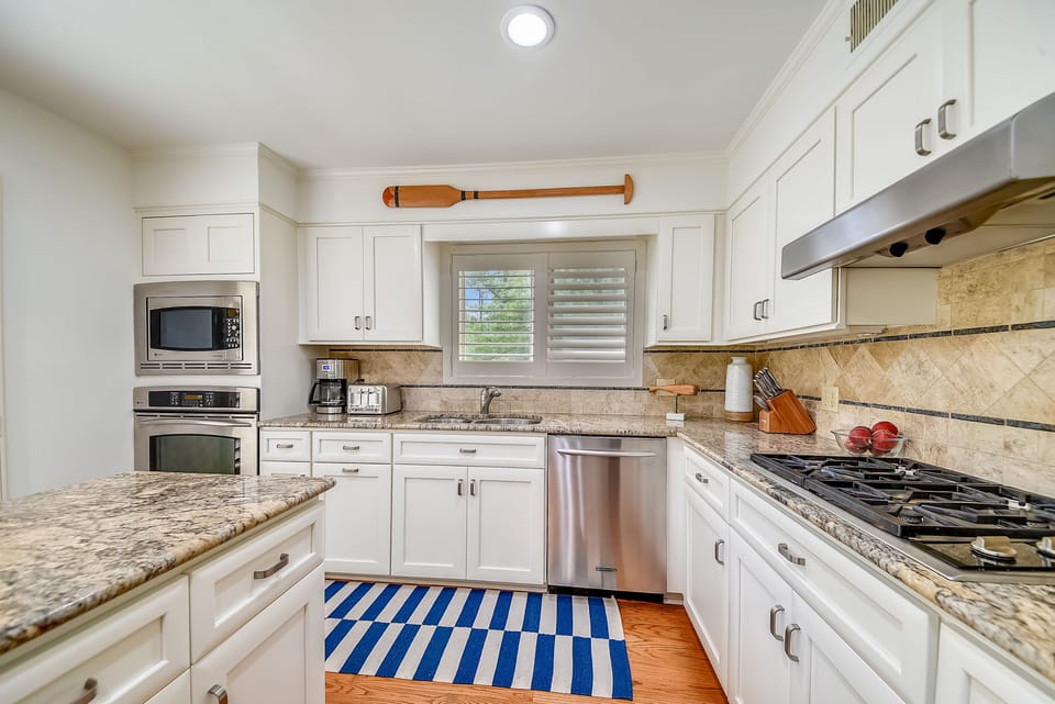 Large kitchen with gas stove, convection oven and large island with seating