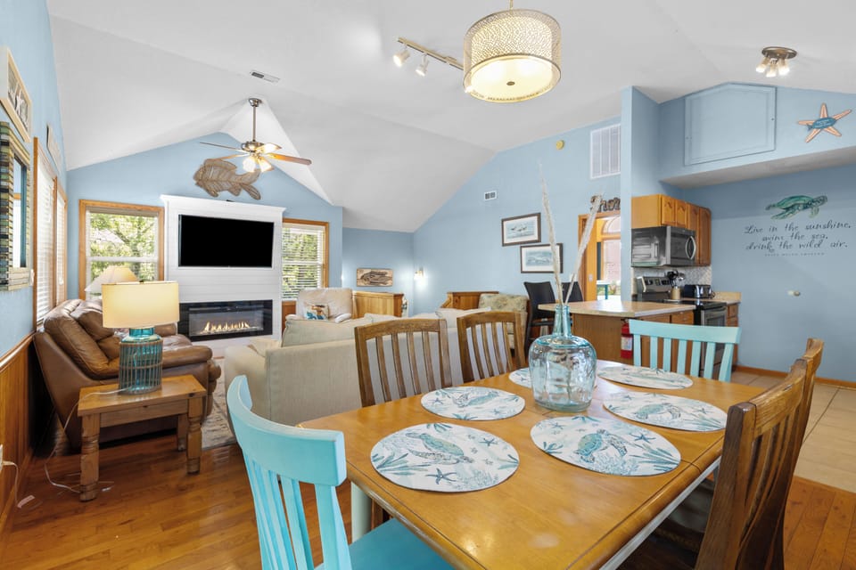 Your beach-themed retreat features an open living space with cozy fireplace, dining for six, and a fully-equipped kitchen—perfect for gathering after a day exploring the coast.