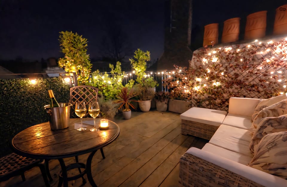 Roof terrace by night, with festoon lighting, outdoor dining and relaxing. 