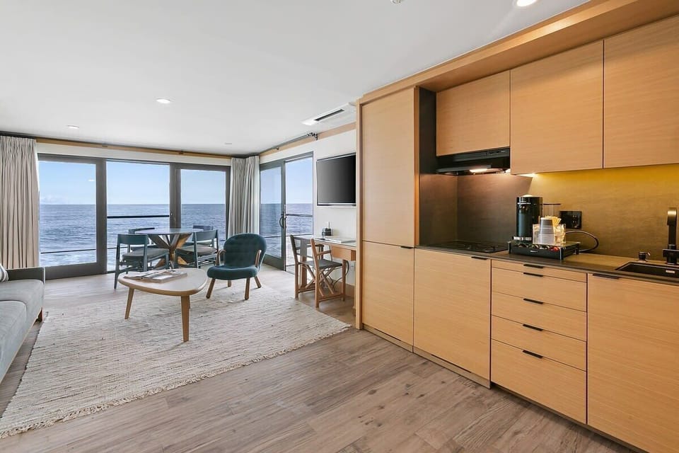 A kitchenette with mini-fridge and freezer, Broan cooktop fully stocked with drinkware, flatware, and dinnerware.  A Nespresso Vertuo, coffee station with pods, Breville toaster oven, iron tea kettle and Ninja blender for preparing smoothies andlight meals