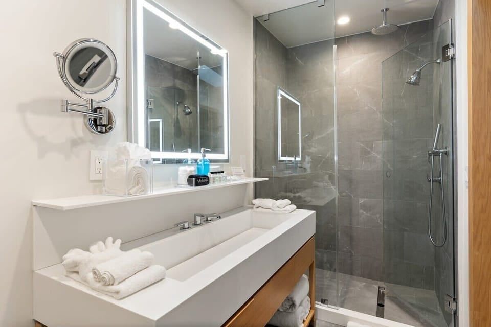 Glass framed showers with a Graff rain shower. Luxurious finishes include Toto Neorest 700 Dual Flush Bidet. Perfectly lit LED vanity.